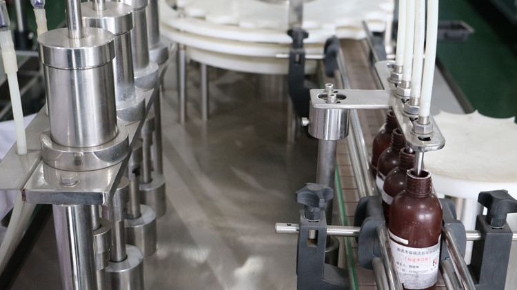 Qopqoqni yopishtirilgan va yulduz g'ildiragi ishlaydigan 500ml dumaloq shisha to'ldirish mashinasi